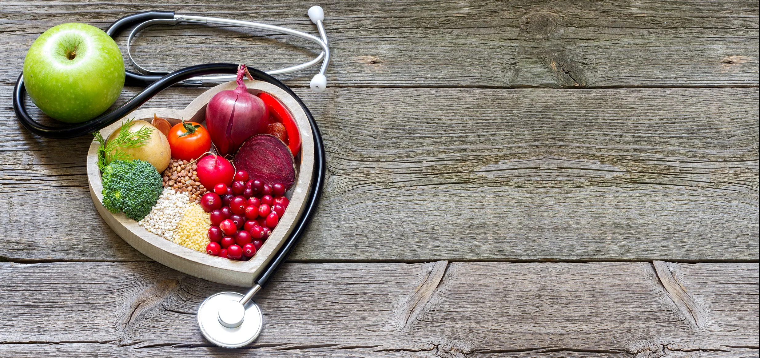 healthy food in a heart shape surrounded by a stethoscope